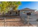 Gray single story home with a well-manicured lawn and chain link fence at 4601 W Wilshire Dr, Phoenix, AZ 85035