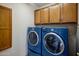 Laundry room with washer, dryer, and wood cabinets at 1017 E Grandview Rd, Phoenix, AZ 85022