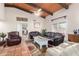 Spacious living room with leather sofas and wood-beamed ceiling at 36444 N Stardust Ln, Carefree, AZ 85377