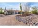 Front view of a ranch-style home with a curved driveway and desert landscaping at 36444 N Stardust Ln, Carefree, AZ 85377