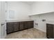 Bright laundry room with dark brown cabinets and tile flooring at 15435 W Bajada Dr, Surprise, AZ 85387