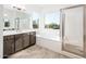 Modern bathroom with double vanity, soaking tub, and walk-in shower at 15435 W Bajada Dr, Surprise, AZ 85387