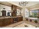 Spa-like bathroom featuring a soaking tub, dual vanities, and a large window at 19481 N 98Th Pl, Scottsdale, AZ 85255