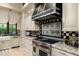 Modern kitchen with stainless steel range, custom cabinetry, and granite countertops at 19481 N 98Th Pl, Scottsdale, AZ 85255