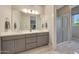 Bathroom with double vanity, glass shower, and marble tile at 13202 E Poinsettia Dr, Scottsdale, AZ 85259