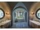Luxurious bathroom featuring a large tub, double vanities, and arched windows at 4836 E White Gates Dr, Phoenix, AZ 85018