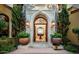 Grand entry with arched doorway, stone accents, and large planters at 4836 E White Gates Dr, Phoenix, AZ 85018