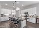 Modern kitchen with white cabinets, large island, and stainless steel appliances at 23680 N 168Th Ln, Surprise, AZ 85387