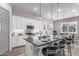 Open concept kitchen with white cabinets, breakfast bar, and stylish lighting at 23680 N 168Th Ln, Surprise, AZ 85387