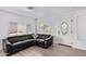 Living room with a spacious black sectional sofa and an entryway with a glass door at 2650 W Union Hills Dr # 258, Phoenix, AZ 85027