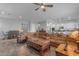 Spacious living room with leather sectional sofa and ceiling fan at 22652 E Munoz St, Queen Creek, AZ 85142