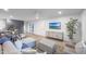 Spacious living area with gray sofa, large TV, and adjacent kitchen at 4331 W Port Au Prince Ln, Glendale, AZ 85306