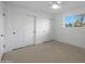 Well-lit bedroom featuring three sliding door closets and a ceiling fan at 4331 W Port Au Prince Ln, Glendale, AZ 85306