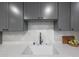 Modern kitchen sink with gray cabinets and white quartz countertops at 4331 W Port Au Prince Ln, Glendale, AZ 85306