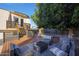 Private backyard oasis with deck, seating area, and mature shade tree at 4331 W Port Au Prince Ln, Glendale, AZ 85306
