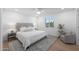 Bright bedroom with king-size bed, gray accent chair, and wood floors at 4331 W Port Au Prince Ln, Glendale, AZ 85306