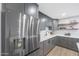 Modern kitchen with gray cabinets, stainless steel appliances, and wood shelving at 4331 W Port Au Prince Ln, Glendale, AZ 85306