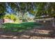 Spacious backyard with grassy area, animal pens, and mature trees at 4331 W Port Au Prince Ln, Glendale, AZ 85306