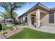 Landscaped backyard with artificial turf, pathway, and covered patio area at 2549 W Shinnecock Way, Anthem, AZ 85086