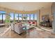Spacious living room with large windows offering scenic views, comfortable seating and a beautiful chandelier at 2549 W Shinnecock Way, Anthem, AZ 85086