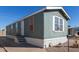 Mobile home exterior, blue siding, white trim, steps, and a small yard at 2600 E Allred Ave # R82, Mesa, AZ 85204