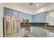 Kitchen features stainless steel appliances and blue cabinets at 218 E Sunburst Ln, Tempe, AZ 85284
