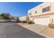 Tan townhome with attached garage, landscaping, and a car parked nearby at 4838 W New World Dr, Glendale, AZ 85302