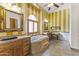 Elegant bathroom with double sinks, a large tub, and yellow striped walls at 6440 E Odessa St, Mesa, AZ 85215