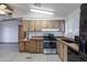 Modern kitchen with wood cabinets, stainless steel appliances, and vinyl flooring at 9302 E Broadway Rd # 9, Mesa, AZ 85208