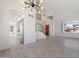 Open living room and kitchen with gray floors and modern chandelier at 1207 N Velero St, Chandler, AZ 85225