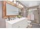 Bathroom with double vanity, large mirror and a walk-in shower at 5702 W Windrose Dr, Glendale, AZ 85304
