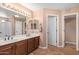Double vanity bathroom with dark wood cabinets and neutral tile floors at 5702 W Windrose Dr, Glendale, AZ 85304