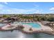Aerial view of community pool with surrounding landscaping and lake at 44395 W Bailey Dr, Maricopa, AZ 85138