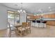 Open kitchen with island, stainless steel appliances, and light wood cabinets at 44395 W Bailey Dr, Maricopa, AZ 85138