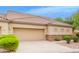 Tan stucco house with a two-car garage and neatly landscaped front yard at 1404 N Desert Willow St, Casa Grande, AZ 85122