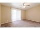 Bedroom with sliding door to patio and neutral colored walls and carpet at 10621 W Oakmont Dr, Sun City, AZ 85351