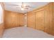 Bright bedroom with wood paneling, carpet, and mirrored closet doors at 7654 E Calypso Ave, Mesa, AZ 85208