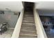 Modern staircase with wood-look laminate treads and a view of the dining and kitchen areas at 2474 E Westchester Dr, Chandler, AZ 85249