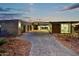 Modern home with a contemporary design, featuring a large driveway and desert landscaping at 2866 S Petroglyph Trl, Gold Canyon, AZ 85118