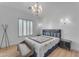 Elegant bedroom with a Fendi headboard, chandelier, and light wood floors at 11312 E Greenway Rd, Scottsdale, AZ 85255