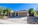 Tan house exterior with a two-car garage and landscaping at 7585 W Tumblewood Dr, Peoria, AZ 85382