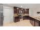 Modern kitchen with dark wood cabinets, granite countertops, and stainless steel appliances at 2660 S 172Nd Dr, Goodyear, AZ 85338