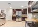 Modern kitchen with dark wood cabinets, granite countertops, and stainless steel appliances at 2660 S 172Nd Dr, Goodyear, AZ 85338