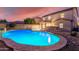 Inviting kidney-shaped pool with surrounding patio and landscape lighting at 2660 S 172Nd Dr, Goodyear, AZ 85338