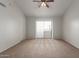Bright bedroom with carpeted floor, ceiling fan, and sliding door to balcony at 6705 W Orchid Ln, Peoria, AZ 85345