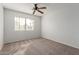 Cozy carpeted bedroom with window and ceiling fan at 6705 W Orchid Ln, Peoria, AZ 85345