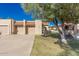 Tan two-car garage with arched entryway and landscaping at 10128 E Minnesota Ave, Sun Lakes, AZ 85248