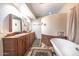 Bathroom with a clawfoot tub, double vanity, and decorative rugs at 15339 E Red Bird Rd, Scottsdale, AZ 85262