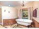 Bathroom with a clawfoot tub, stained glass window, and decorative rug at 15339 E Red Bird Rd, Scottsdale, AZ 85262