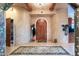 Entryway with an arched wooden door, decorative rug, and coat rack at 15339 E Red Bird Rd, Scottsdale, AZ 85262